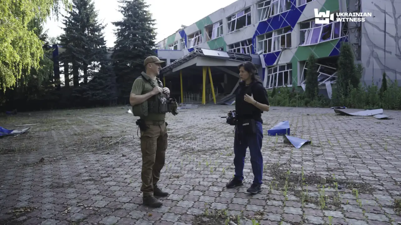 krasnopilska shkola ведуча та військовий на фоні школи в Краснопіллі