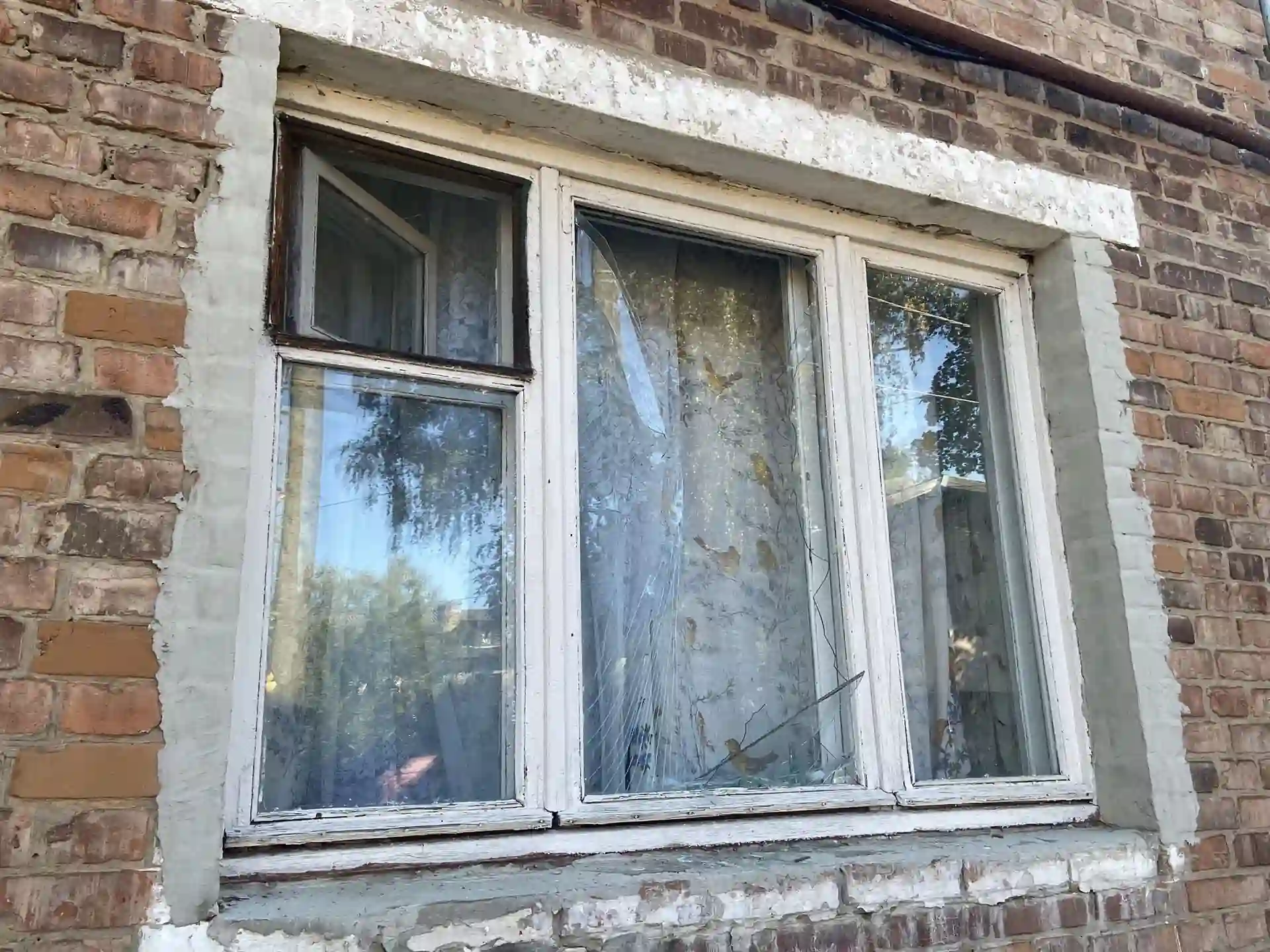 Пошкоджене вікно в будинку внаслідок обстрілу