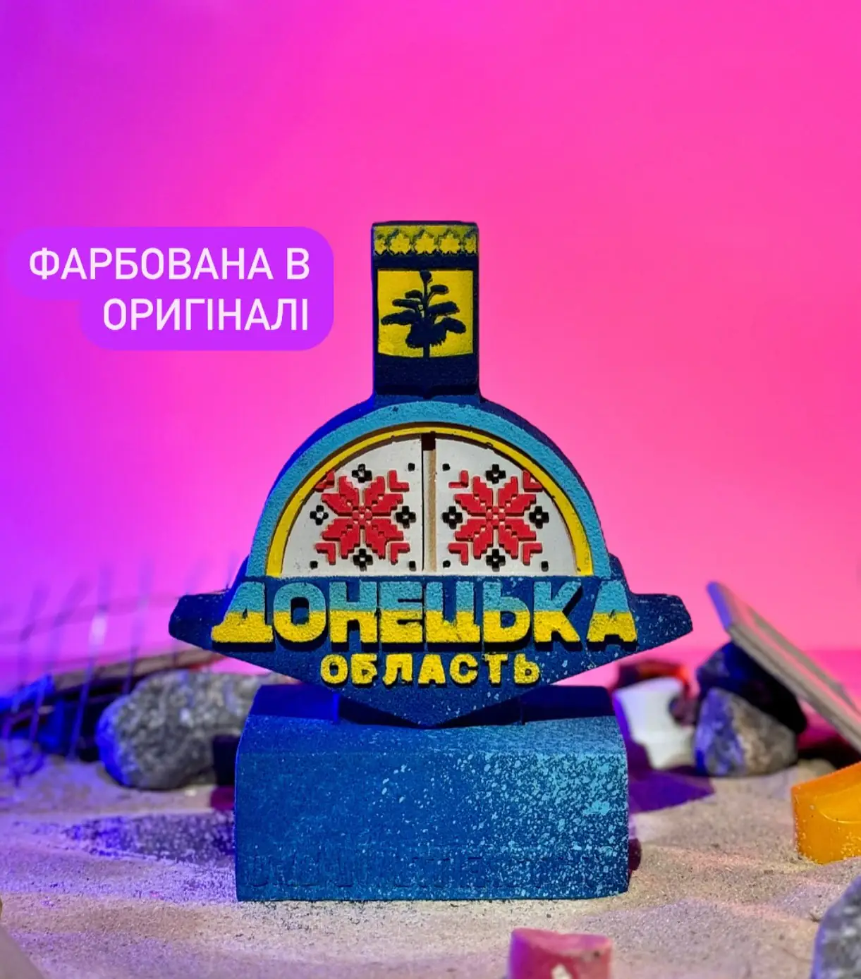 Копію донецької стели сфотографували на фоні камінців та інших прикрас, що ніби імітують ландшафт області.