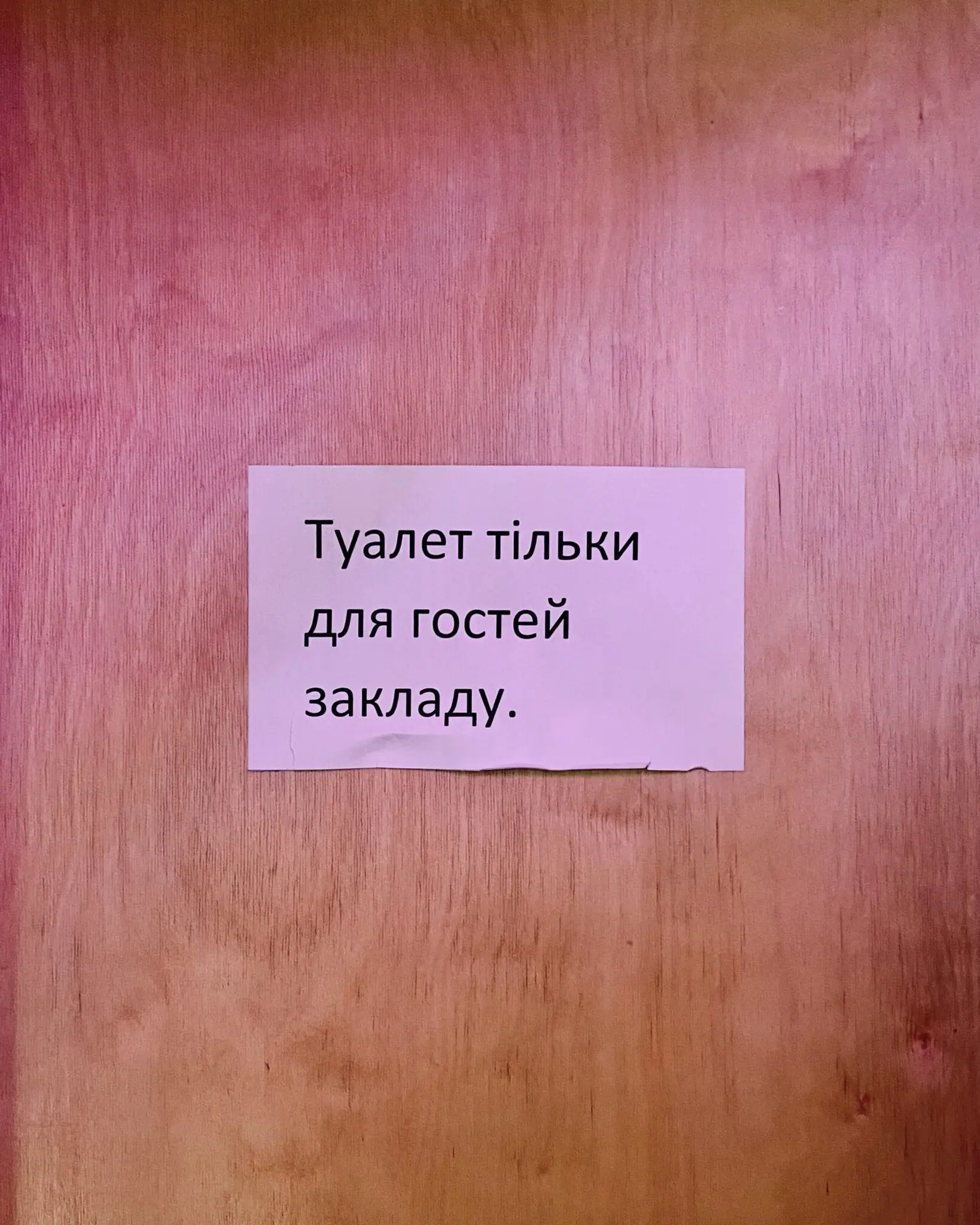 На дверях до вбиральні висить табличка із написом «Туалет тільки для гостей закладу».