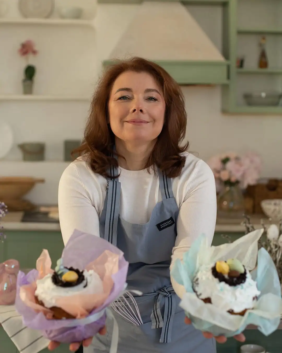 Жінка стоїть з десертами