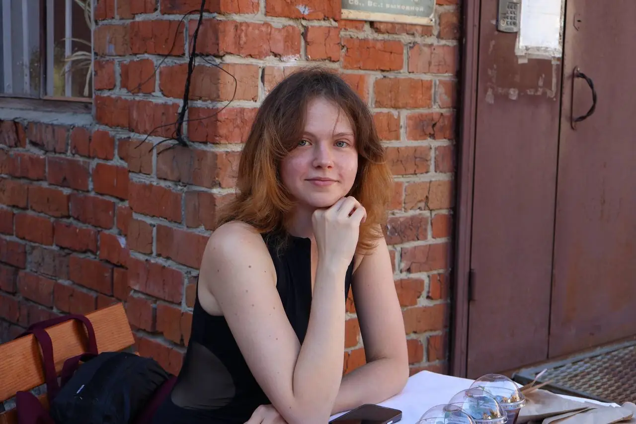 Дівчина сидить за столом