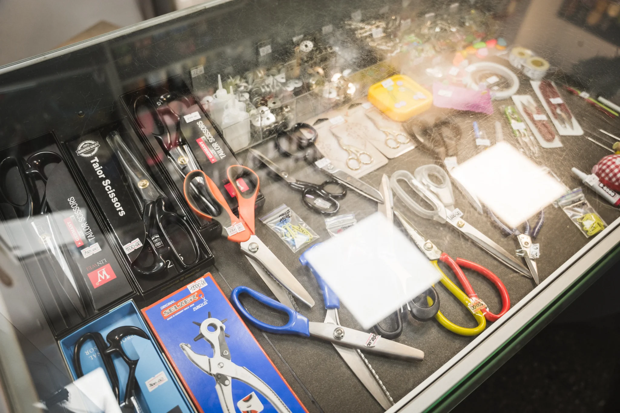 Ножиці, ґудзкики та інші деталі розклали на вітрині.