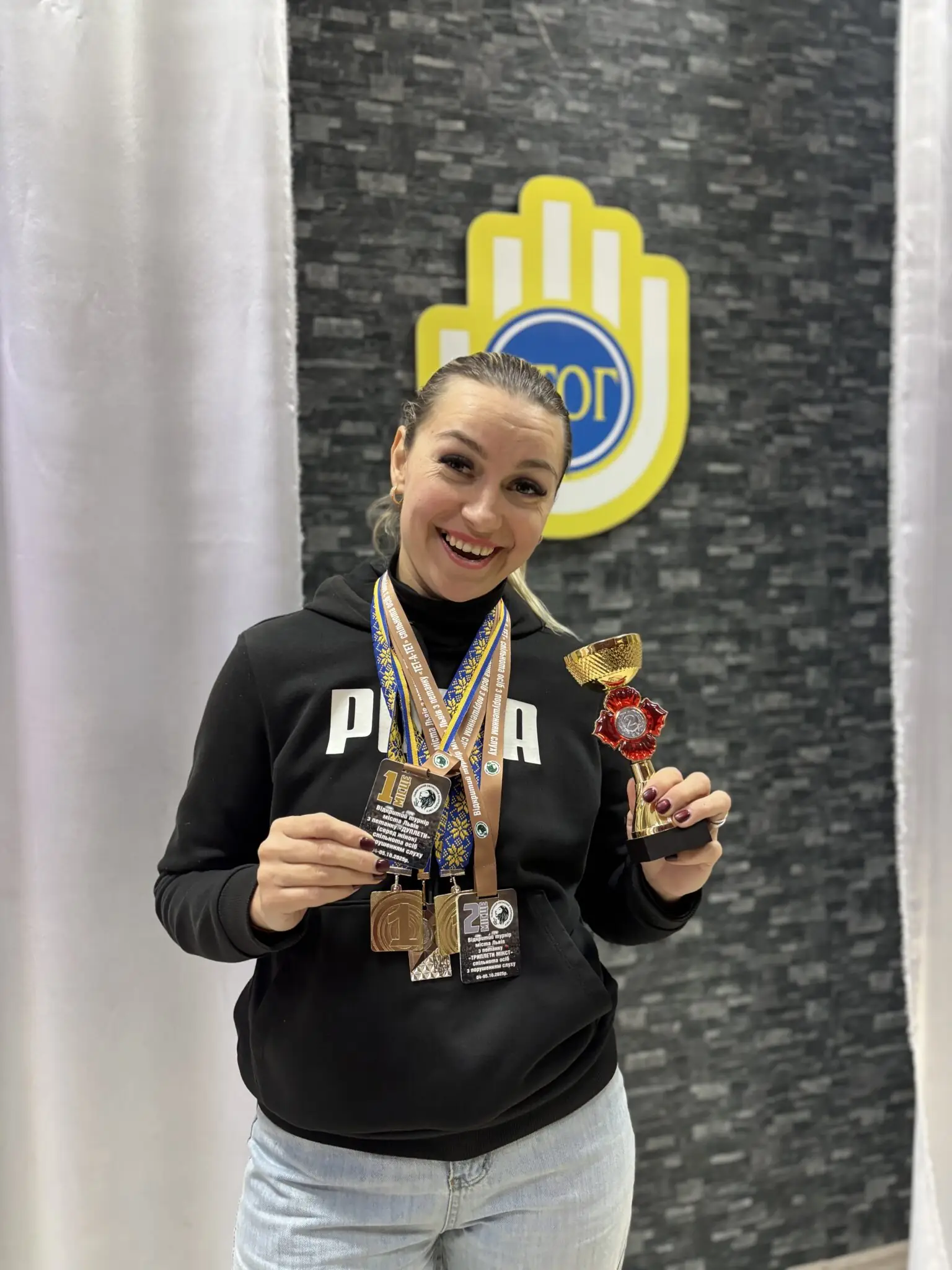 Учасниця Українського товариства глухих в Сумах Ірина показує спортивні нагороди