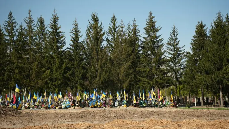 Над Баранівським кладовищем майорять десятки синьо-жовтих прапорів.