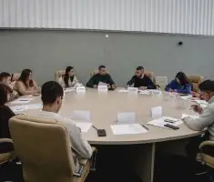 На засіданні Сумської міської ради чиновники сидять за круглим столом. Вони обговорюють мораторій.