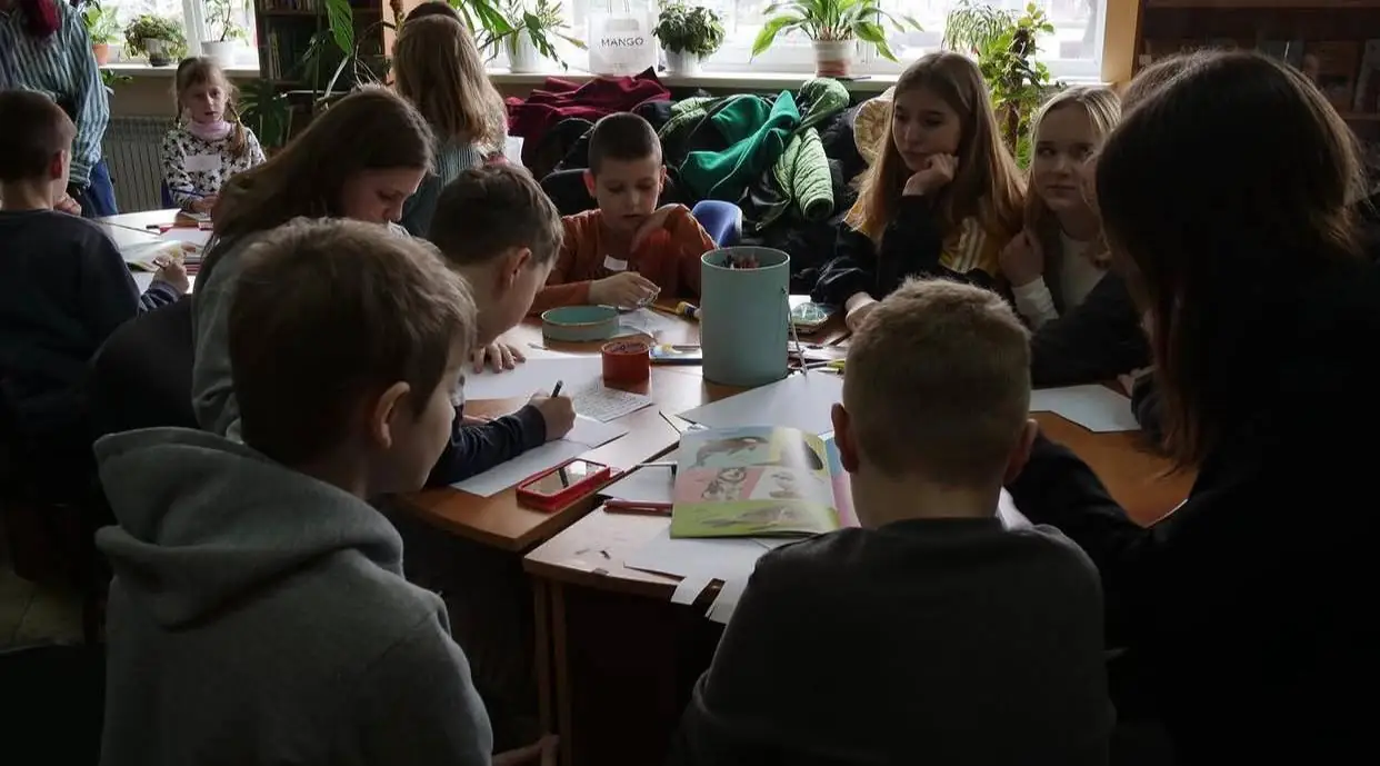 Діти зібралися в коло. Вони обговорюють важливі теми та розфарбовують картинки.