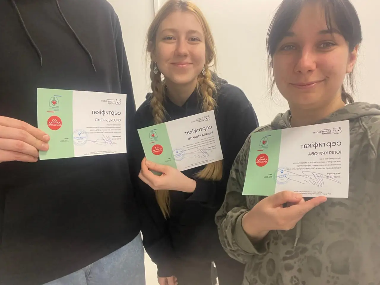 Юля та її друзі тримають у руках сертифікати. Вони пройшли курси з тактичної медицини.