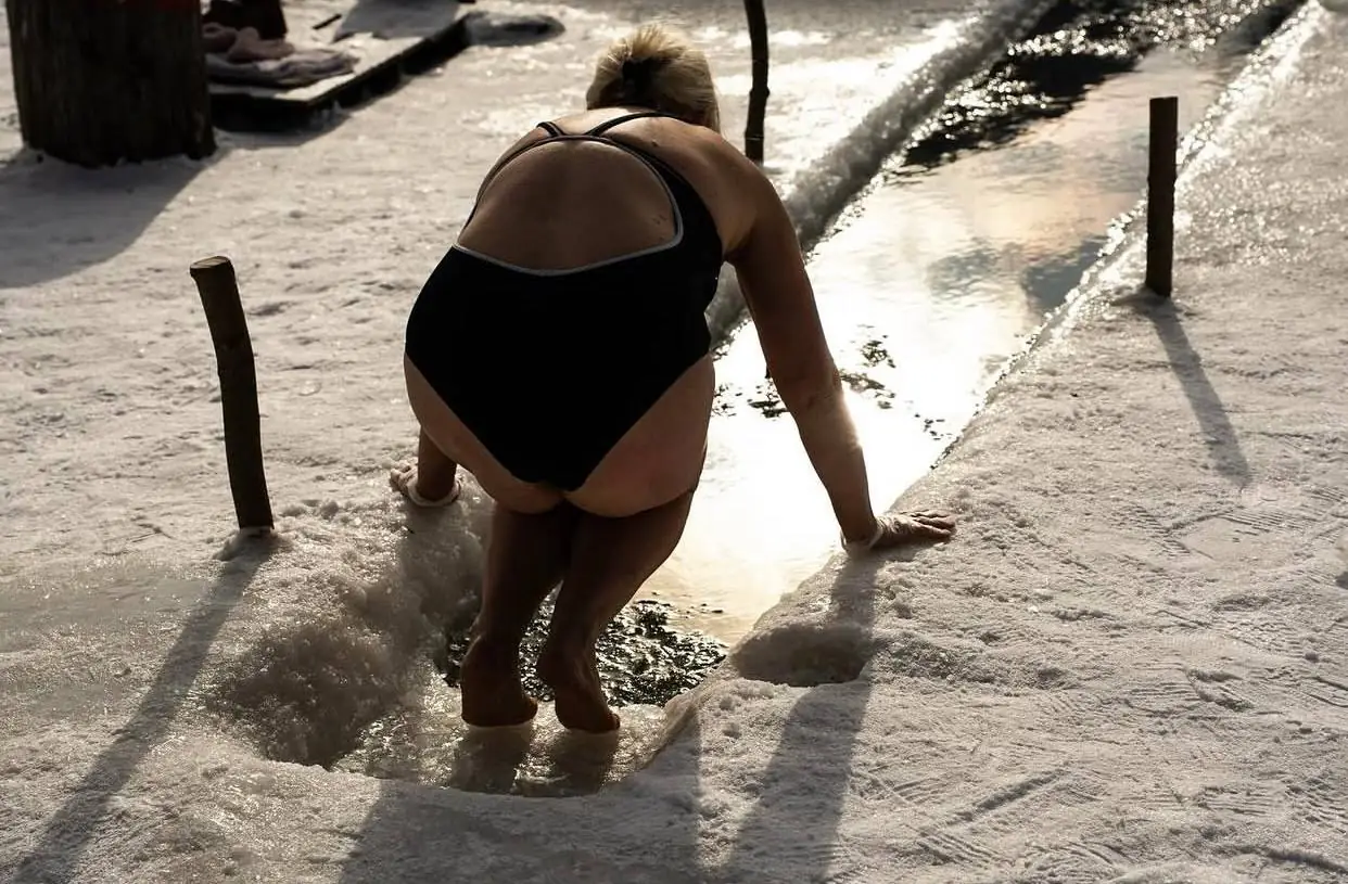 Олена в купальнику пірнає в річку в лютому.