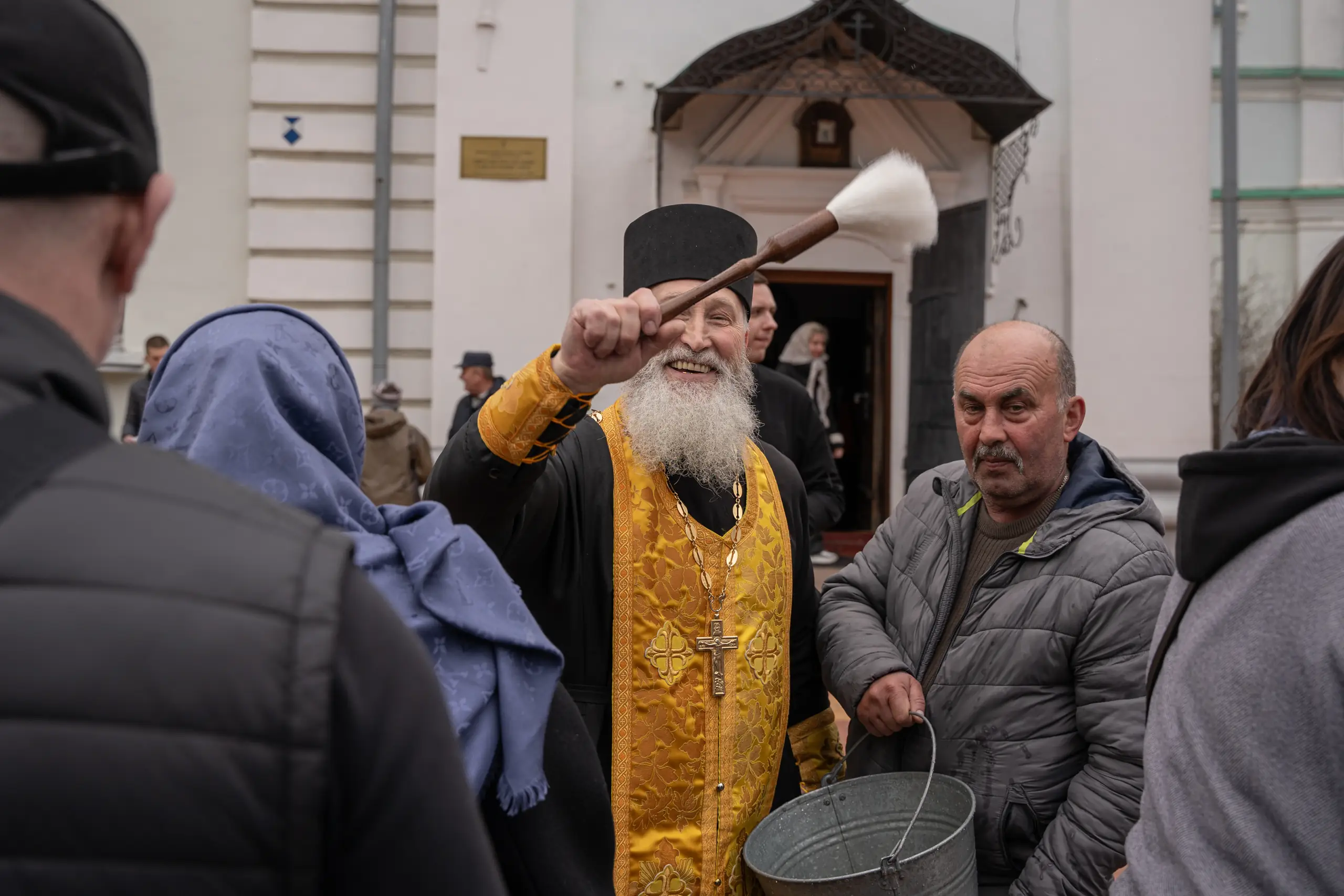 Панотець кропить фотографа у черзі