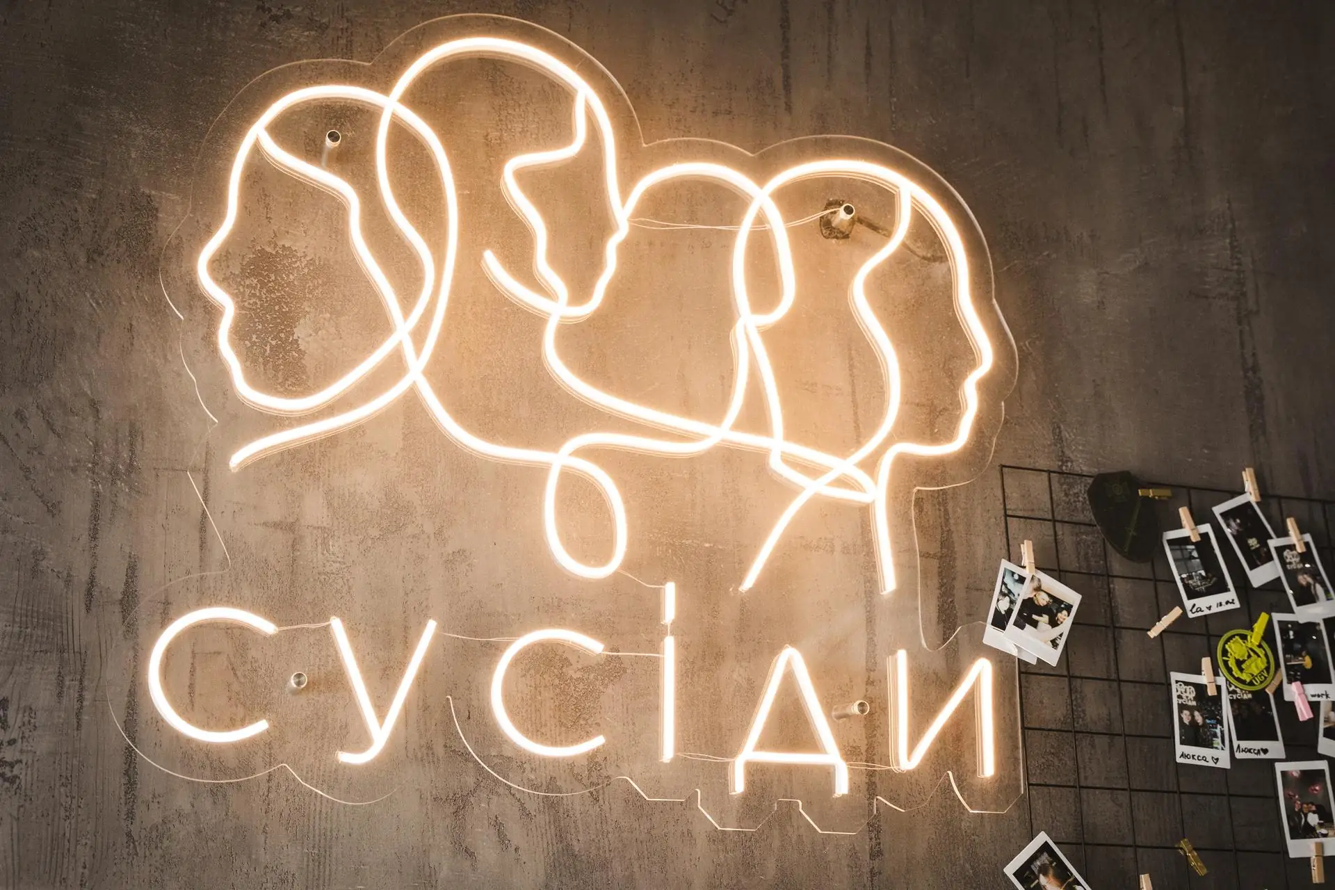 Неонова вивіска «Сусіди» на стіні