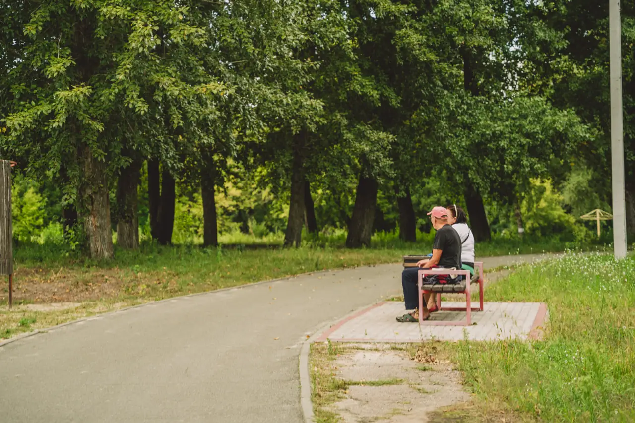люди сидять на лаві у Сумах