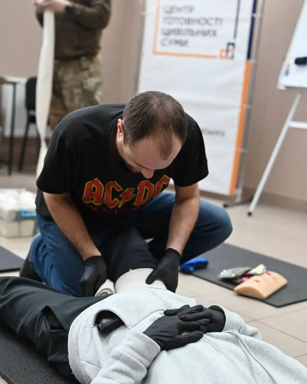 Чоловік накладає пов'язку на тренінгу з домедичної допомоги в Сумах